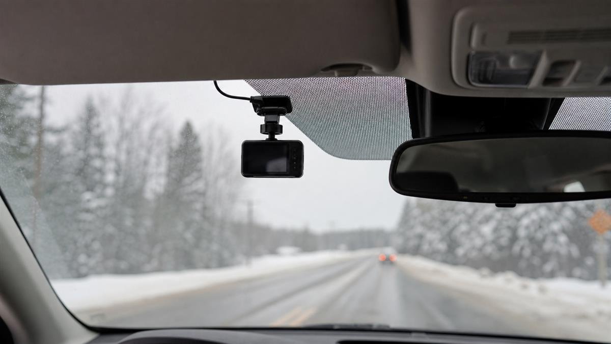 Dash cam mounted behind a windshield during snowy winter driving